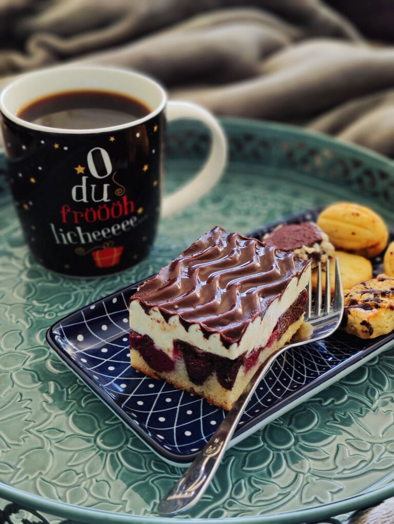 Saftiger Marmorkuchen mit Kirschen, cremiger Vanille-Buttercreme und knackiger Schokoladenglasur – der klassische Blechkuchen für jede Gelegenheit.