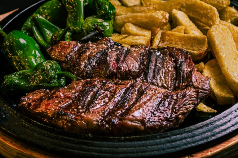 Saftiges Steak mit gerösteten Pimientos de Padrón, würziger Mojo-Sauce und knusprigen Pommes aus dem Airfryer – mediterraner Genuss für zuhause.